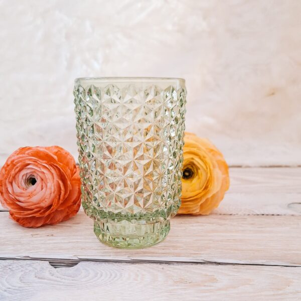 jasnozielony wazon o kryształowej fakturze na tle papierowych jaskrów